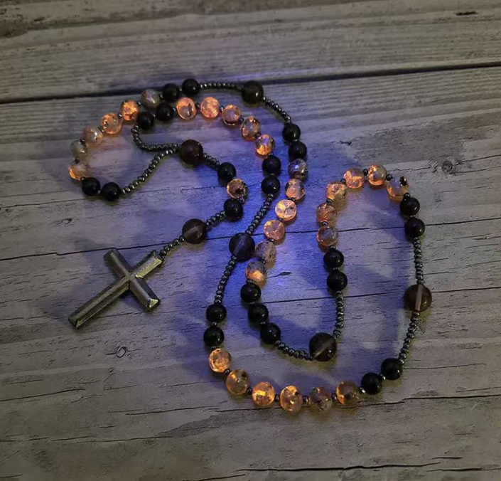 Rosary necklace glowing under ultraviolet light