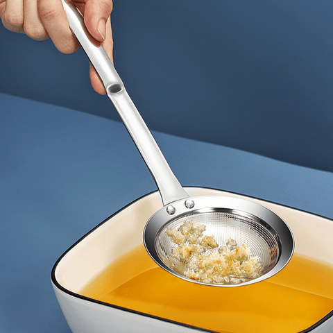 Fine mesh skimmer removing fried food crumbs from oil